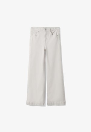 Pantaloni beige chiaro a gamba larga, vita alta, con bottoni anteriori, zip, passanti per cintura e design a cinque tasche, distesi su uno sfondo bianco.