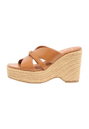 Brązowy skórzany sandał na koturnie z krzyżującymi się paskami i plecioną podeszwą z juty na białym tle.