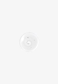 Witte, romige lotion met een zachte textuur en een draaipatroon, gepresenteerd in een cirkelvorm tegen een lichte achtergrond.