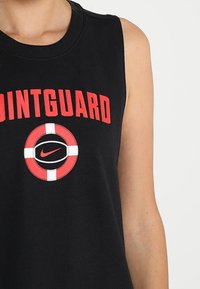 Svart ärmlös t-shirt med texten "POINTGUARD" i röd. Har en cirkulär grafisk logotyp från Nike i rött, svart och vitt i mitten.