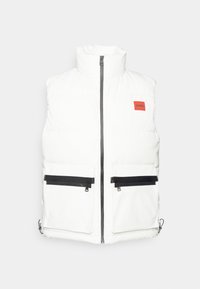 Weißer gepolsterter Weste mit hohem Kragen, Vorderreißverschluss, zwei schwarzen Reißverschlusstaschen und einem roten Markenlabel auf der linken Brust. Glatte Stoffstruktur.