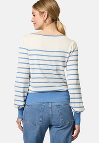 Maglione a righe in crema e blu con orlo e polsini blu a costine. Tessuto morbido, maniche lunghe e scollatura rotonda. Vestibilità casual.