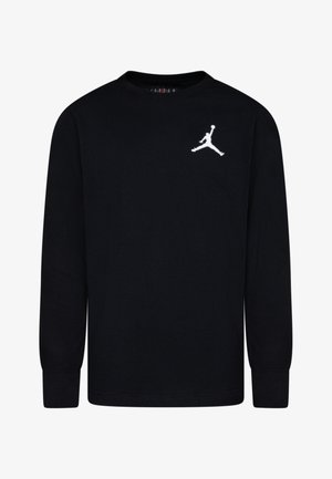 Črna majica dolgih rokavov iz bombaža, ki ima beli Jumpman logotip na levem prsnem delu. Klasičen kroj z okroglim izrezom in rebrastimi robovi.