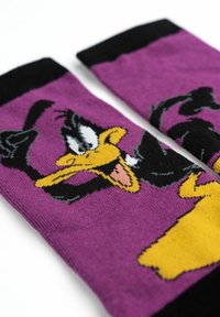 Calze viola con un design di Daffy Duck e accenti neri. La texture è a maglia, con un vivace giallo e dettagli sul viso.