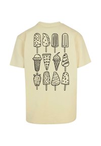 Cremefarvet t-shirt med sorte stregtegninger af forskellige isdesserter, herunder isvafler, ispinde og svungne former på ryggen.