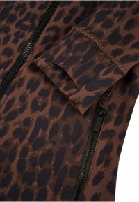 Veste en imprimé léopard dans des tons marron et sombres ; dotée d'un zip noir, d'un tissu doux et d'un détail de poignet replié.