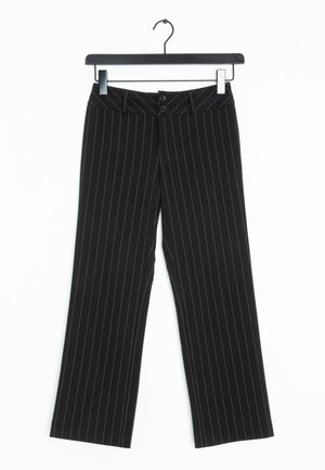 Pantalons à rayures noires avec une coupe large. Dispose de deux boutons à la taille et d'une texture lisse. Suspendus à un cintre noir.