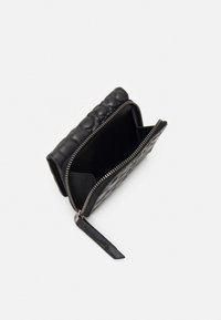 Schwarzes Lederportemonnaie mit einem gesteppten Muster, Reißverschluss und kontrastierendem Innenraum. Mit einem Leder-Reißverschlussanhänger.