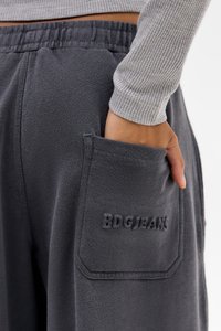 Grå sweatpants har en tekstureret overflade, elastisk liv, og en sidelomme med prægede "BDG/JEAN" bogstaver.