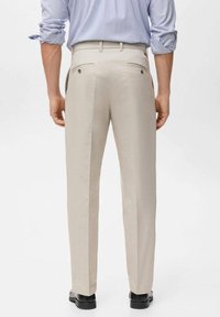 Beige broek met een gladde textuur, voorzien van twee achterzakken. Het ontwerp heeft een rechte snit en subtiele zijnaden.