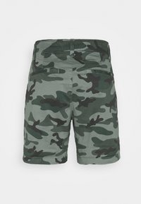 Gröna camouflageshorts i bomull. Har midjemått i midjan, två bakfickor och en slät textur med varierande mörkgröna mönster.