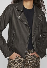 Schwarze Kunstleder-Motojacke mit asymmetrischem Reißverschluss, Druckknopfkragen und zwei Reißverschlusstaschen; mit strukturiertem Finish und taillierter Passform.