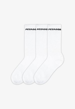 Trois paires de chaussettes blanches côtelées avec un texte noir "PEZADO" sur le bandeau supérieur. Les chaussettes ont une texture lisse et un design de bout arrondi.