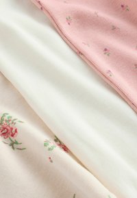Three layers of fabric: pink with small flowers, white ribbed texture, and light pink with floral pattern. Soft knit material throughout.