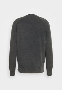 Ciemnoszara bluza z miękką teksturą, rękawami raglanowymi oraz ściągaczami na mankietach i dole. Widok od tyłu ukazuje minimalistyczne detale i gładką, nieoznaczoną tkaninę.