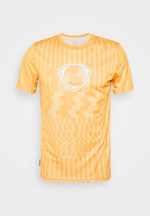 Žluté sportovní tričko s krátkým rukávem s geometrickým vzorem a bílým logem Nike uprostřed na hrudi.