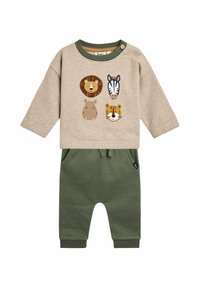 Beige langemouwen top met dierapplicaties (leeuw, zebra, nijlpaard, tijger) en groene manchetten, gecombineerd met groene sweatpants met zakken.