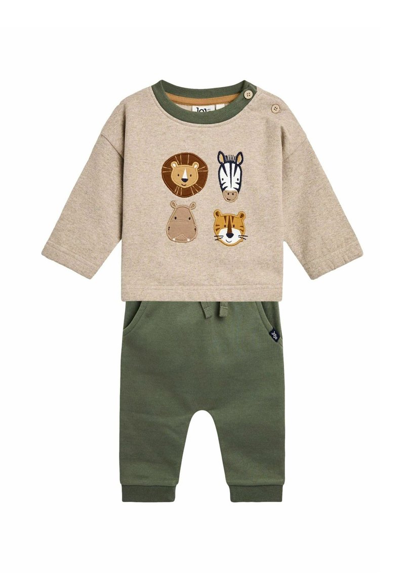 Beige langemouwen top met dierapplicaties (leeuw, zebra, nijlpaard, tijger) en groene manchetten, gecombineerd met groene sweatpants met zakken.