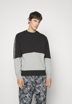 Kaksitooniline sviiter musta ja halli värviga, millel on ümar kaelus, soonikkoes varrukad ja logodetail varruka ääres. Pehme kangatekstuur.