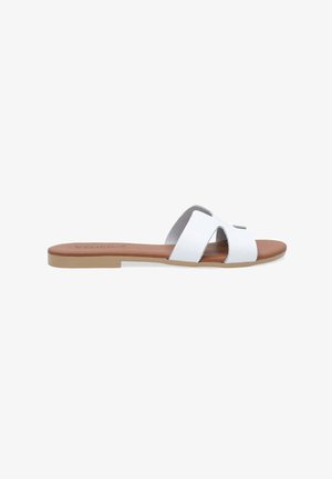 White slide sandals with cross straps, smooth leather upper, brown faux leather insole, and flat light tan rubber outsole. Minimalist design.