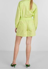 Lime green short-sleeve shirt and matching shorts in lightweight fabric, featuring an elastic waistband and two back pockets.