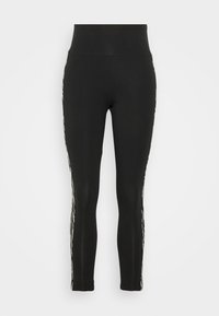 Black leggings with a high waistband, featuring a textured white stripe pattern along the outer sides. Made from stretchy fabric.