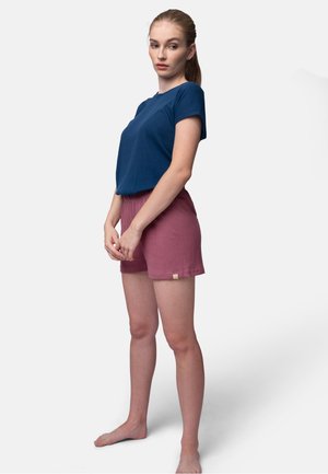 Navy-blaues, geripptes T-Shirt mit kurzen Ärmeln, kombiniert mit pinken, strukturierten Shorts; die Shorts sind am Saum mit einem kleinen Markenetikett versehen.