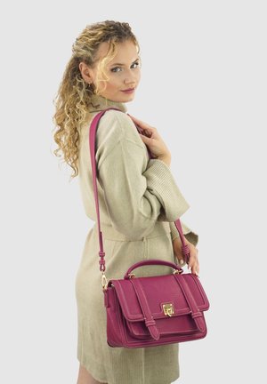 Fuchsia leather handbag with a structured design, top handle, and adjustable strap. Features gold hardware and white stitching accents.