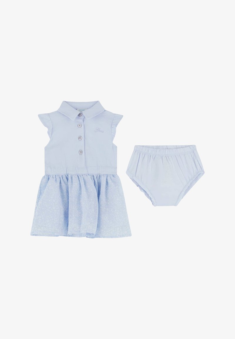 Abito azzurro chiaro con una chiusura a bottone sul davanti, colletto e maniche arricciate. Accompagnato da pantaloni coordinati azzurro chiaro. Morbida texture del tessuto.