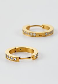Boucles d'oreilles en or avec une finition lisse, comportant une rangée de strass clairs et étincelants le long du bord extérieur. Design arrondi et fermeture sécurisée.