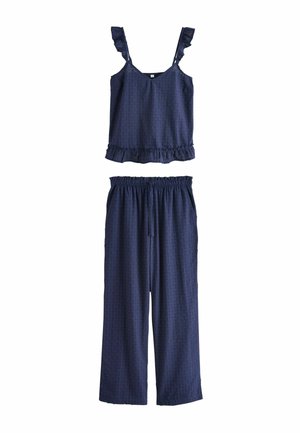 Haut sans manches bleu marine avec bretelles et ourlet volantés, associé à un pantalon à jambes larges et taille élastique assorti. Tissu doux et texturé.