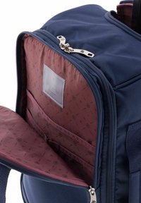 Zaino blu navy con cerniere argentate. L'interno presenta una fodera bordeaux con motivo geometrico e molteplici tasche a fessura per l'organizzazione.