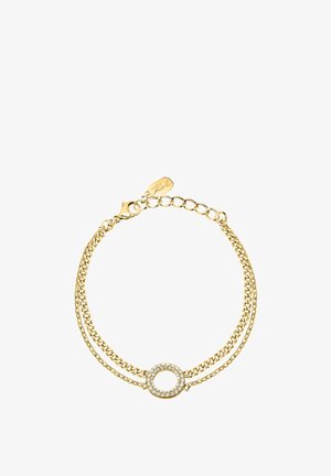 Guldarmbandskedja med två band, med ett runt spänne prytt med små klara kristaller och en märkeslapp.