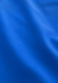 Glat, blåt stof med bløde folder og subtil tekstur, jævnt oplyst med let skygge over overfladen.