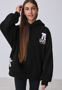 Felpa nera con cappuccio in tessuto morbido. Presenta testo ricamato rosa "Ted Baker" sul davanti e un dettaglio grafico sulla manica.
