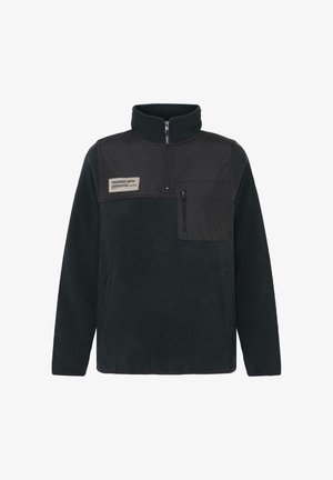 Fleece pullover i mørk navy, med lynlås foran, høj krave og et kontrasterende sort brystpanel med lomme og etiketdetaljer.