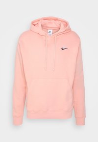 Sudadera de Nike en rosa claro con un bolsillo frontal y capucha con cordón. Tiene un logo negro de Nike en el pecho y puños y dobladillo acanalados.