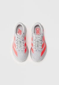 Chaussures de sport gris clair avec des rayures roses vives. Tige en maille et semelle en caoutchouc. Dotées de lacets et de l'inscription "ADIDERO" sur la languette.