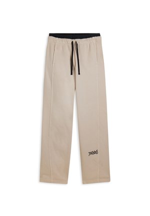 Pantalon beige décontracté avec cordon noir, taille élastique, poches latérales et petit logo noir "Freddy" près de la cheville gauche.
