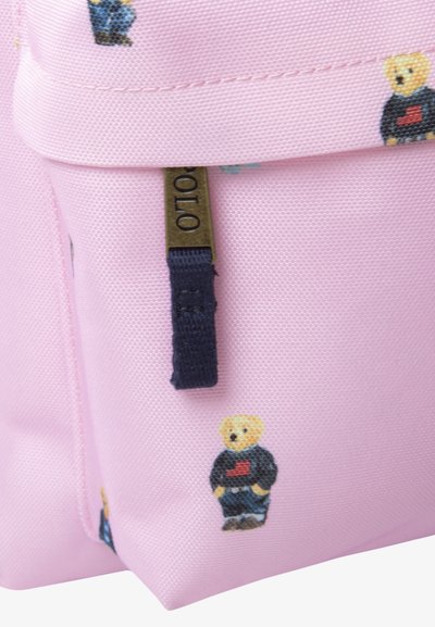 Sac à dos rose avec des motifs d'ours. Présente un tissu texturé, un tirette de fermeture éclair bleue et des broderies détaillées d'ours en vêtements décontractés.