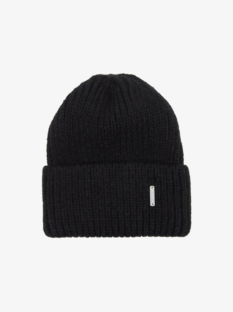Zwarte geribde beanie gemaakt van dik gebreid materiaal, met een omgeslagen rand en een klein metalen logo-label aan de zijkant.