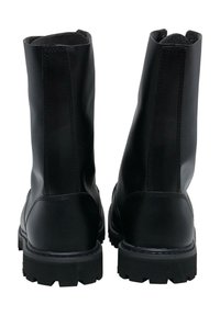 Botas de tobillo negras con un acabado de cuero brillante, costuras reforzadas y suelas de goma resistentes. Presentan una textura suave y un caña alta.