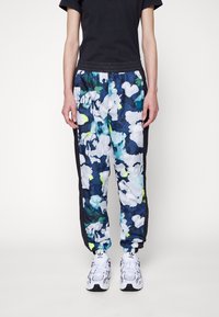 Multifarvede trackpants med et blomsterdesign i blå, hvid og grøn, med sorte sidelæg og en elastisk talje. Gummieret logo-detalje.