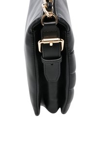 Borsa a mano in pelle nera con texture trapuntata, dettagli in oro, tracolla regolabile e profilo sottile. Vista ravvicinata che mette in risalto i dettagli delle cuciture.