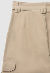 Beige Cargo-Shorts aus glattem Stoff mit flachem Bund, zwei Gürtelschlaufen und einer großen Seitentasche mit Klappe.