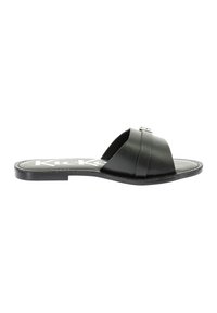 Sandale plate noire avec design à strap croisé, en cuir lisse, semelle rembourrée et un accent argenté minimaliste sur la sangle.