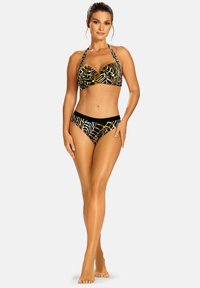 Zestaw bikini charakteryzuje się czarną bazą z kolorowymi wzorami liści. Górna część typu halter ma strukturalny krój, natomiast pas jest w jednolitym czarnym kolorze.