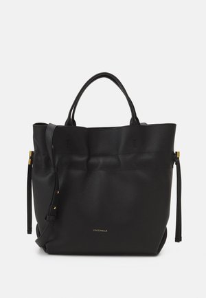 Bolso tote de cuero negro con asas dobles, correa ajustable para el hombro y detalles en tono dorado, con un logo sutil de la marca en el frente.
