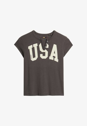 Camiseta gris de manga corta hecha de algodón, con cuello redondo, tapeta de tres botones y gran impresión blanca "USA" en la parte delantera.