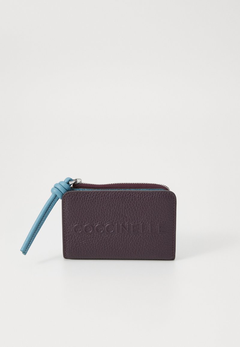 Portafoglio in pelle viola con texture e zip blu. Presenta il nome del marchio in rilievo sulla parte anteriore e ha una forma rettangolare compatta.